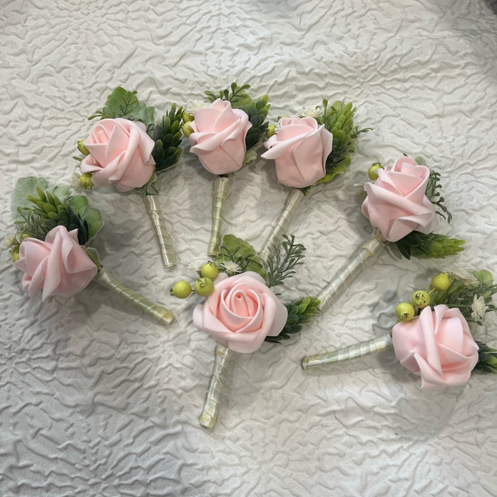 7 🌹 rose boutonnières in soft pink shade with light green greenery accents.